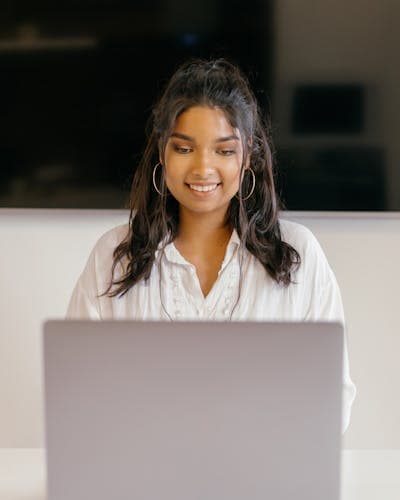 Indian student smiling with laptop